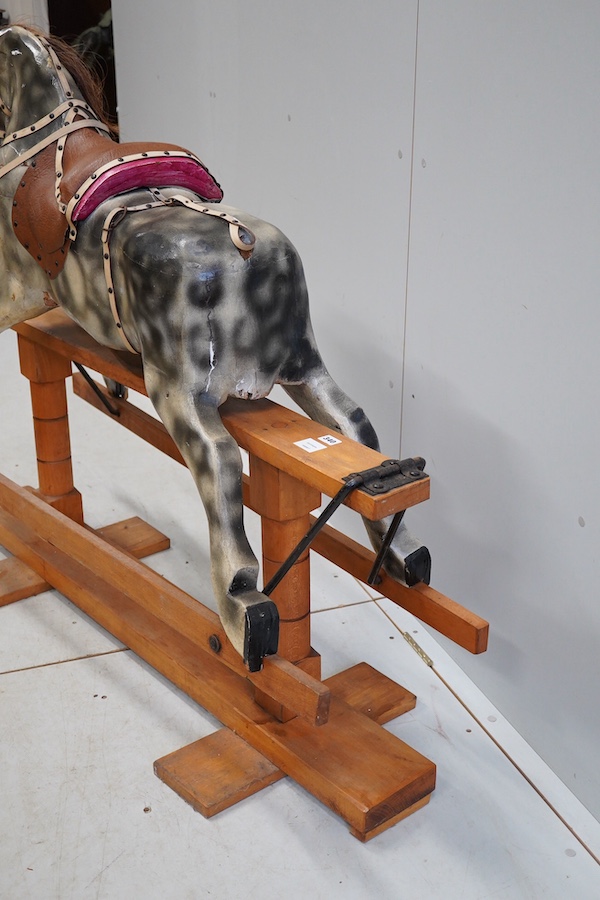 An early 20th century dapple grey rocking horse, on later trestle base, length 132cm. Condition - fair.